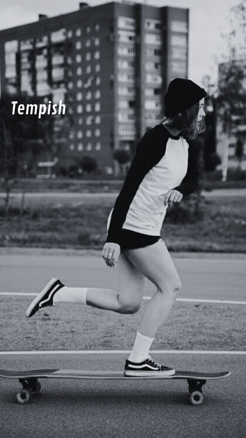 Person skateboarding on a street with buildings in the background - urbaneight