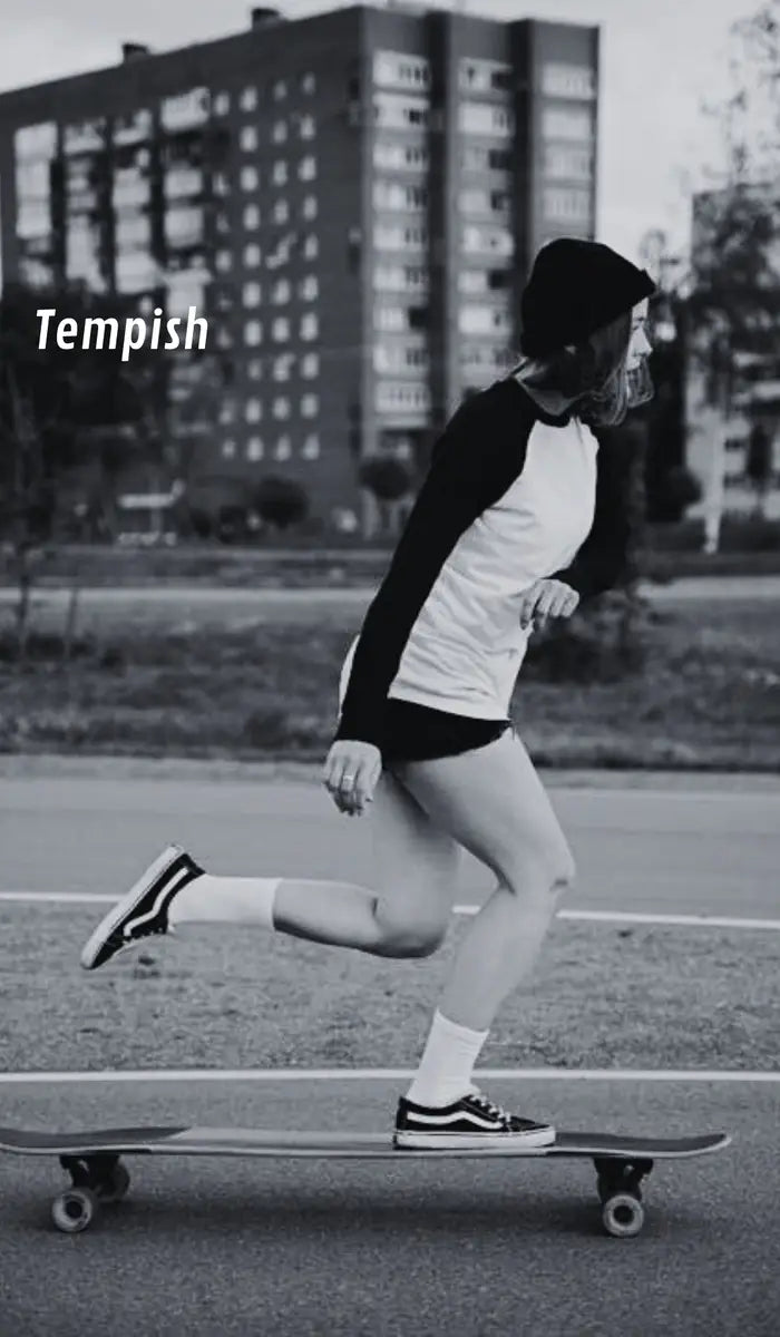 Person skateboarding on a street with buildings in the background
